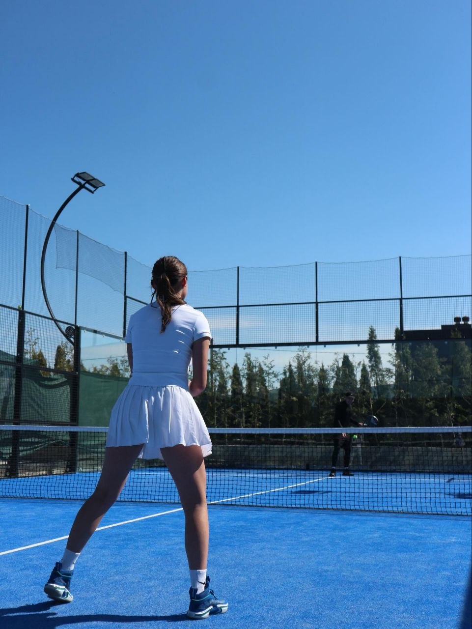 Tennis player on blue court in daylight